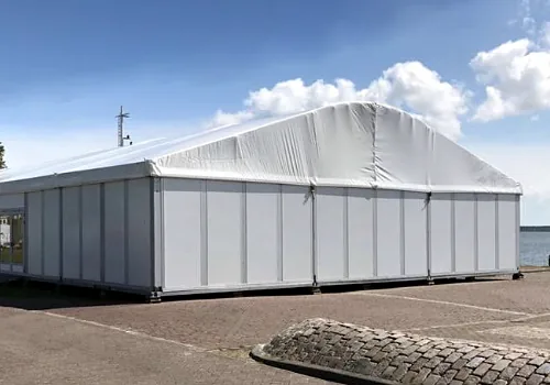 Een witte alu-hal van buiten, opgebouwd op een kade