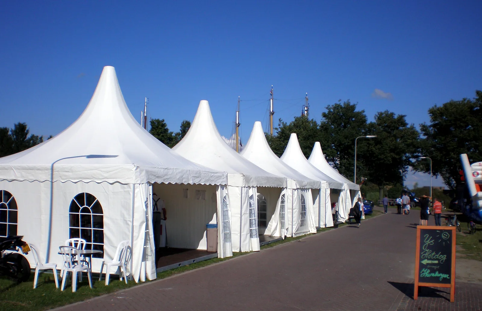 Een rij witte pagodetenten langs een pad tijdens een evenement